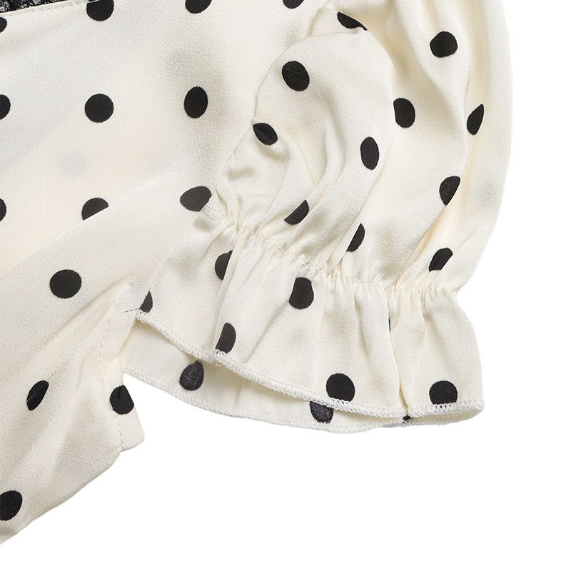 Robe longue élégante à pois et col en V, ornée de dentelle.