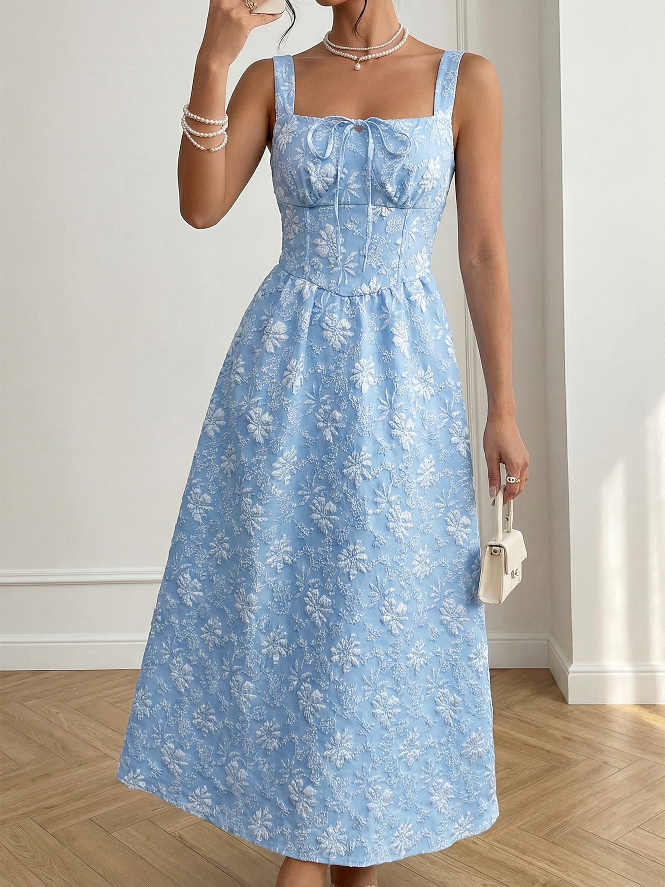 Abito midi azzurro chiaro con scollo quadrato e ricami floreali.