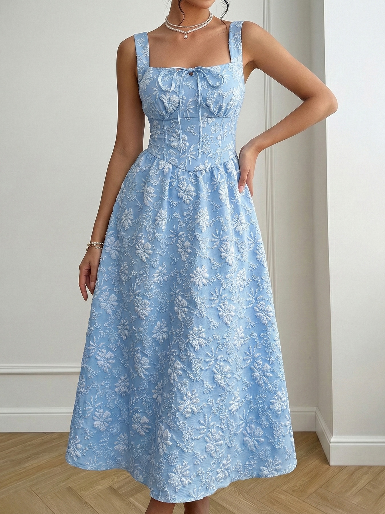 Abito midi azzurro chiaro con scollo quadrato e ricami floreali.