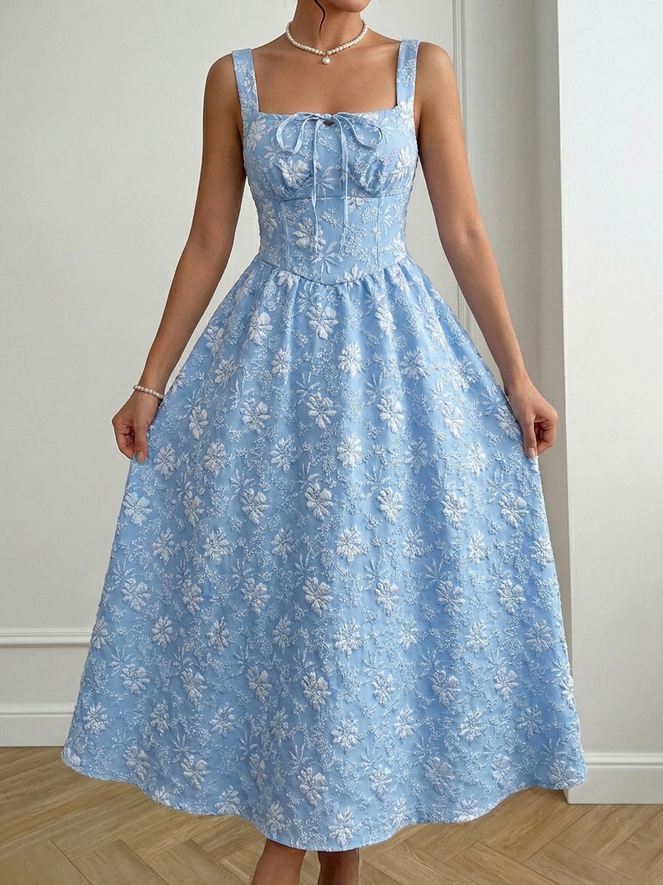 Abito midi azzurro chiaro con scollo quadrato e ricami floreali.