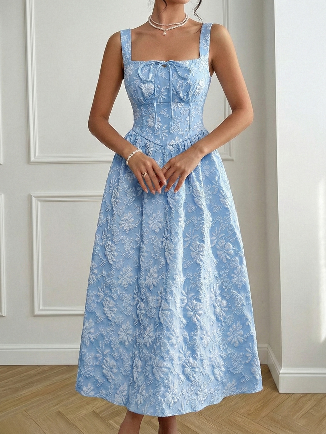 Abito midi azzurro chiaro con scollo quadrato e ricami floreali.