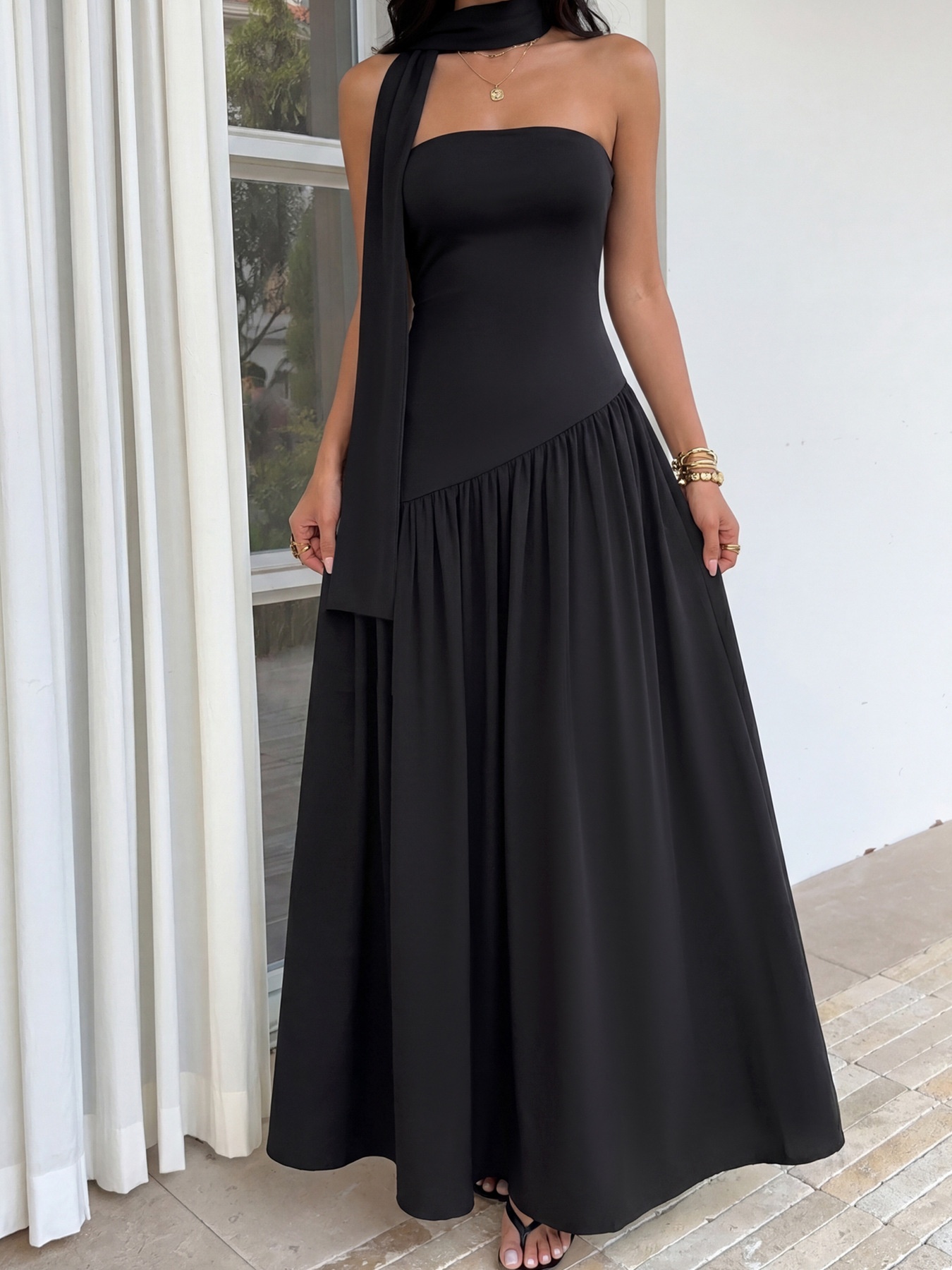 Elegante vestido largo negro sin tirantes con detalle de pañuelo.