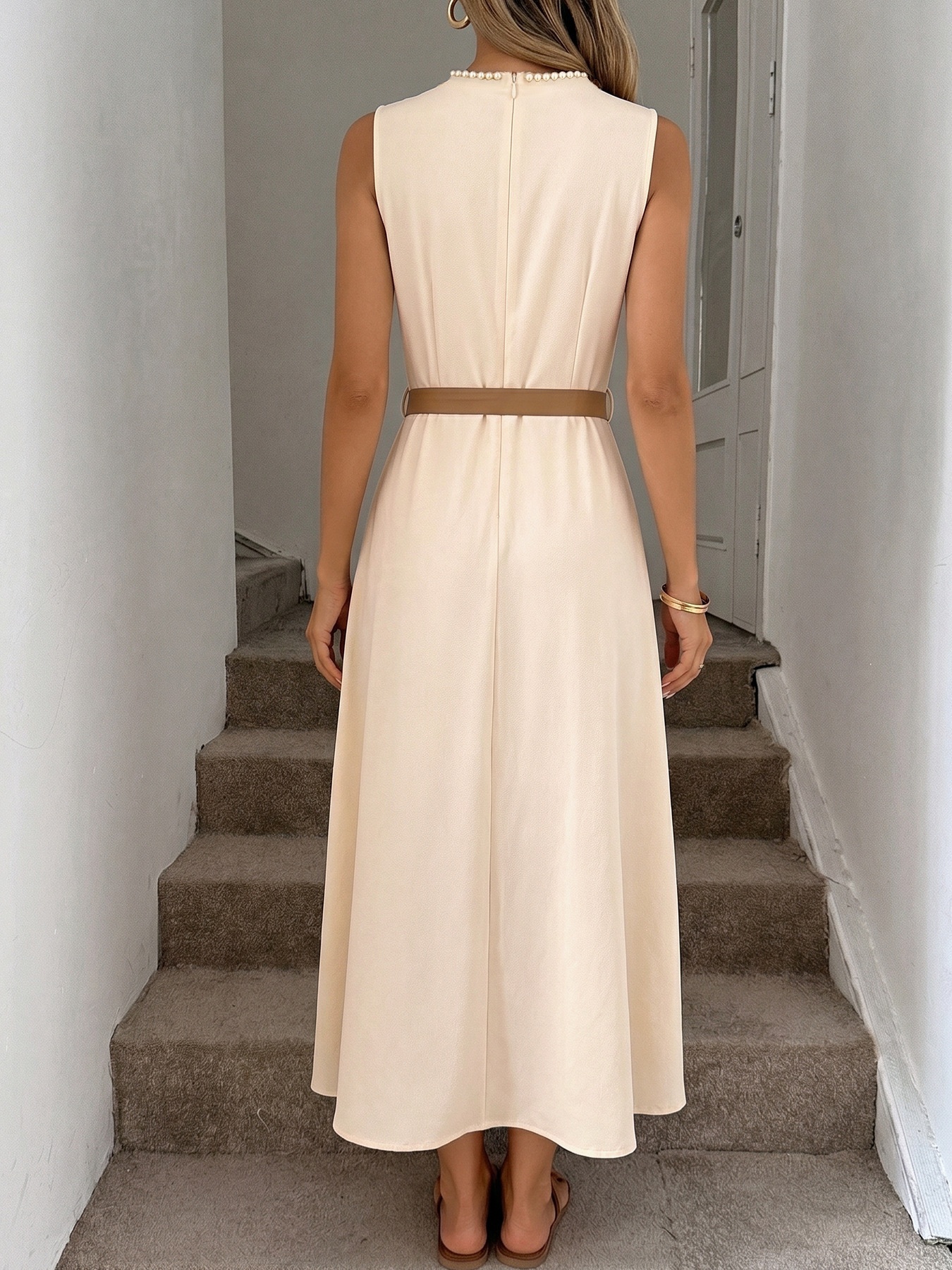 Abito midi beige senza maniche con cintura e rifiniture in perle.