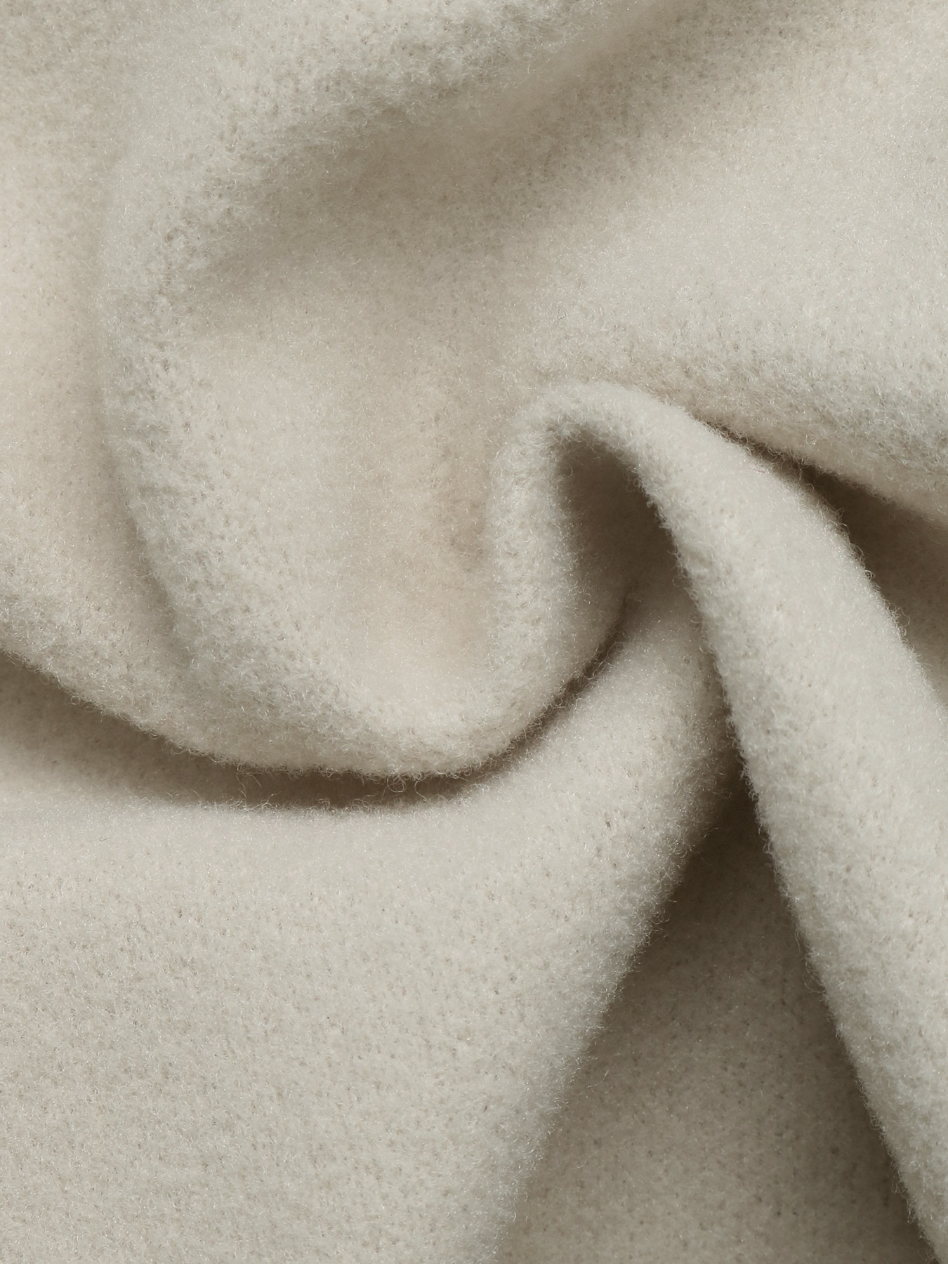 Cappotto beige con cintura e abbottonatura frontale, con colletto a revers.