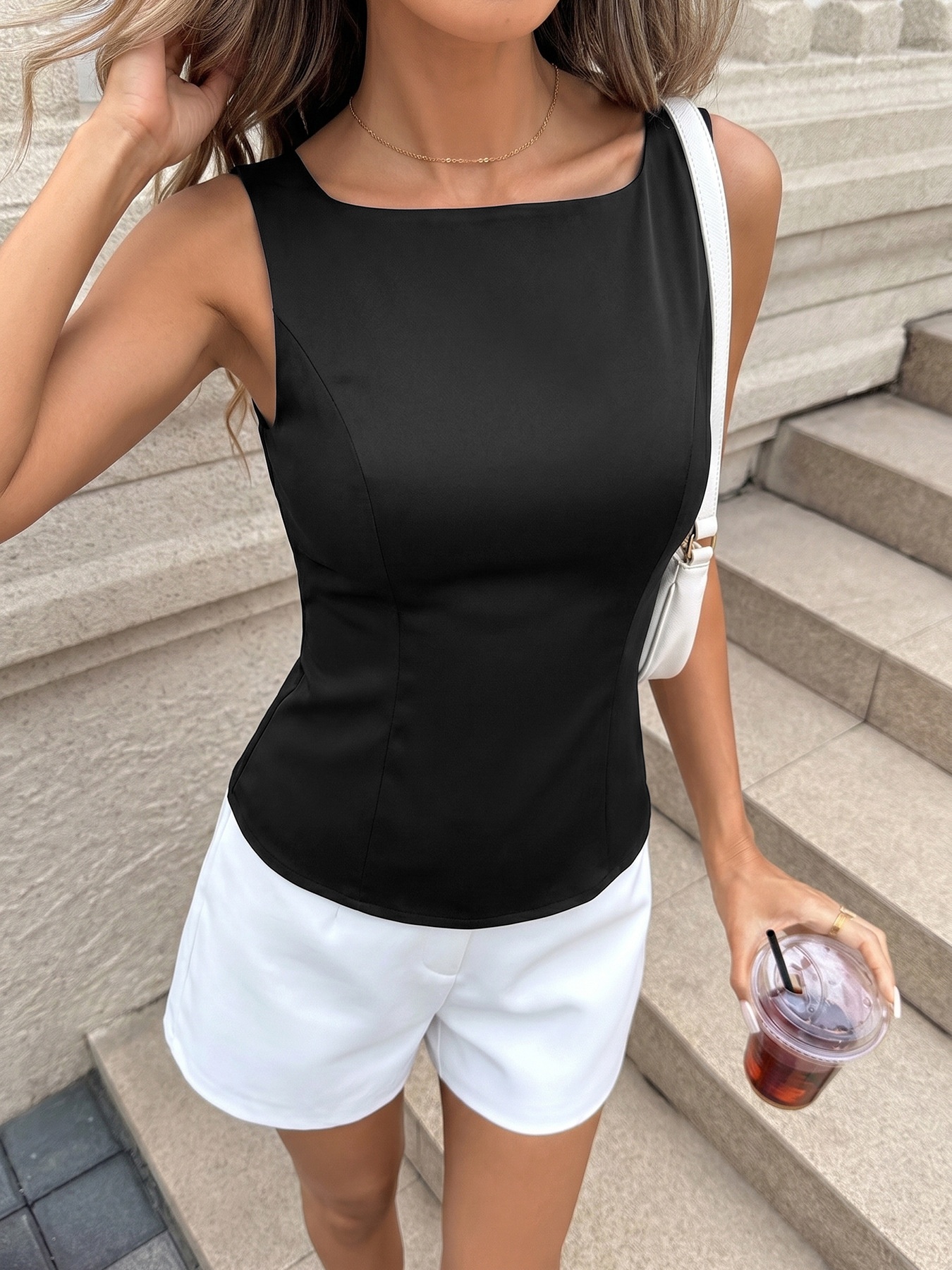 Elegante top senza maniche da donna con scollo a barca e fiocco sulla schiena.