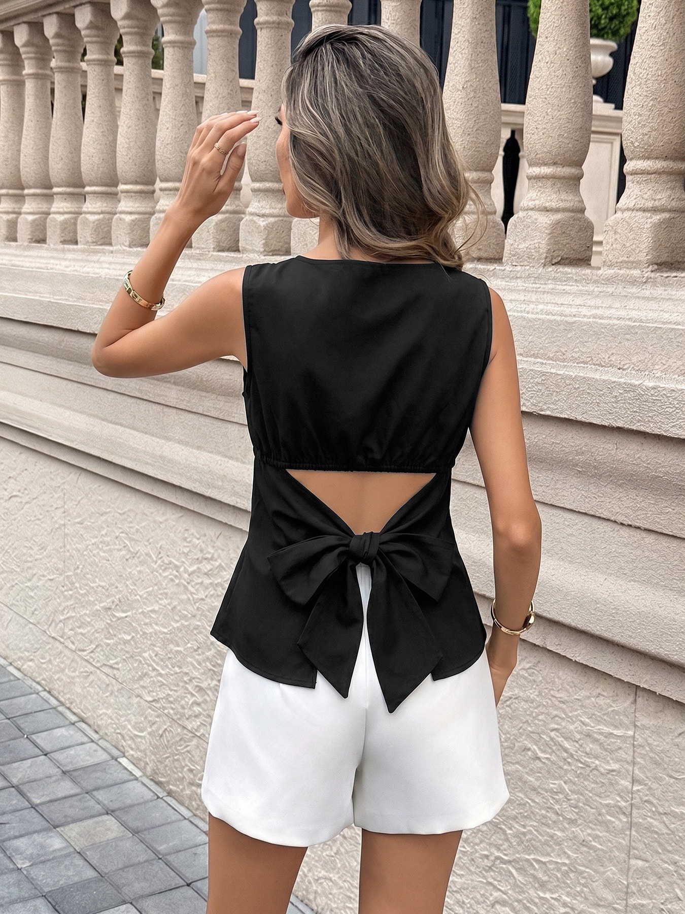 Elegante top senza maniche da donna con scollo a barca e fiocco sulla schiena.