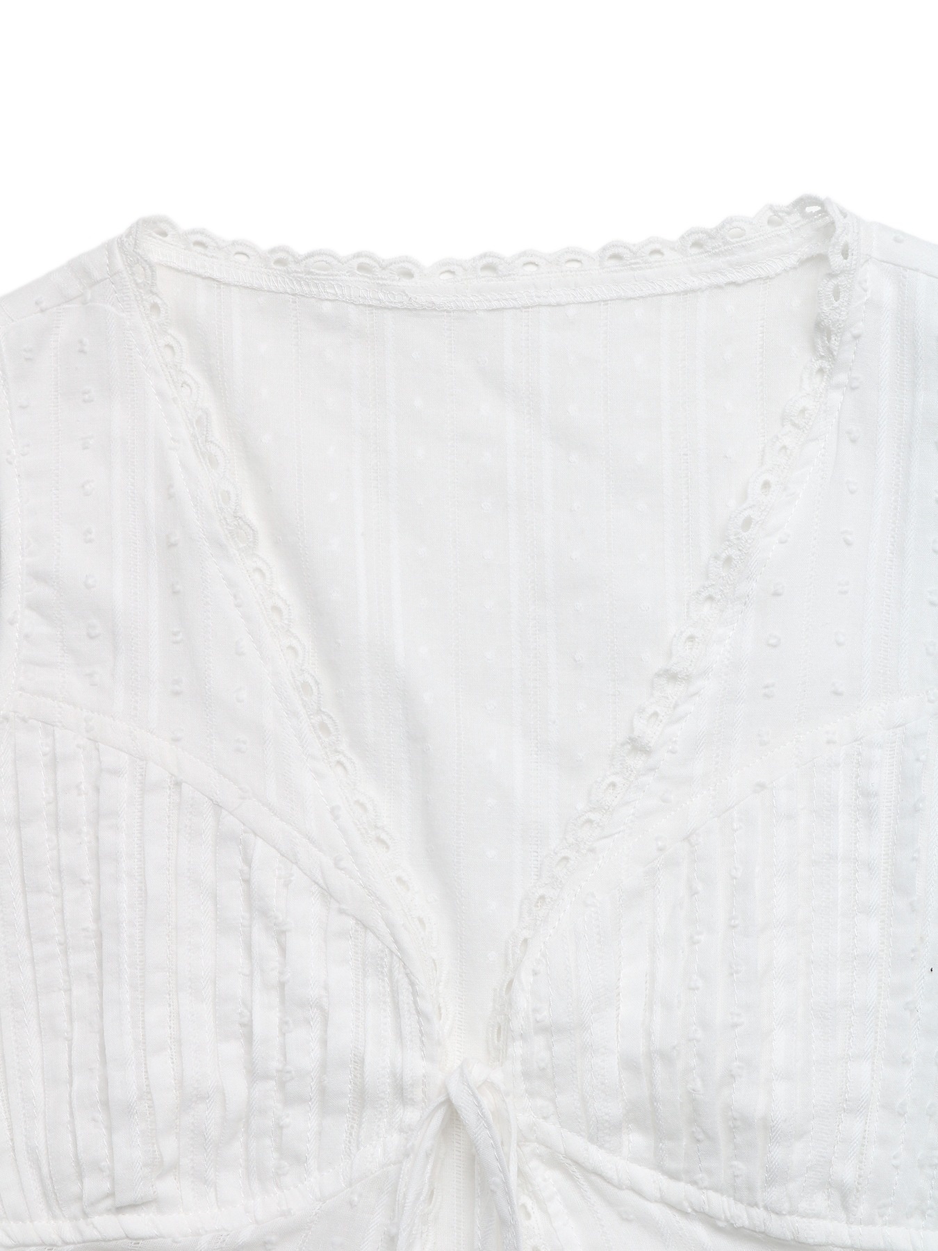 Top bianco senza maniche con scollo a V e allacciatura sul davanti, con bordo in pizzo.