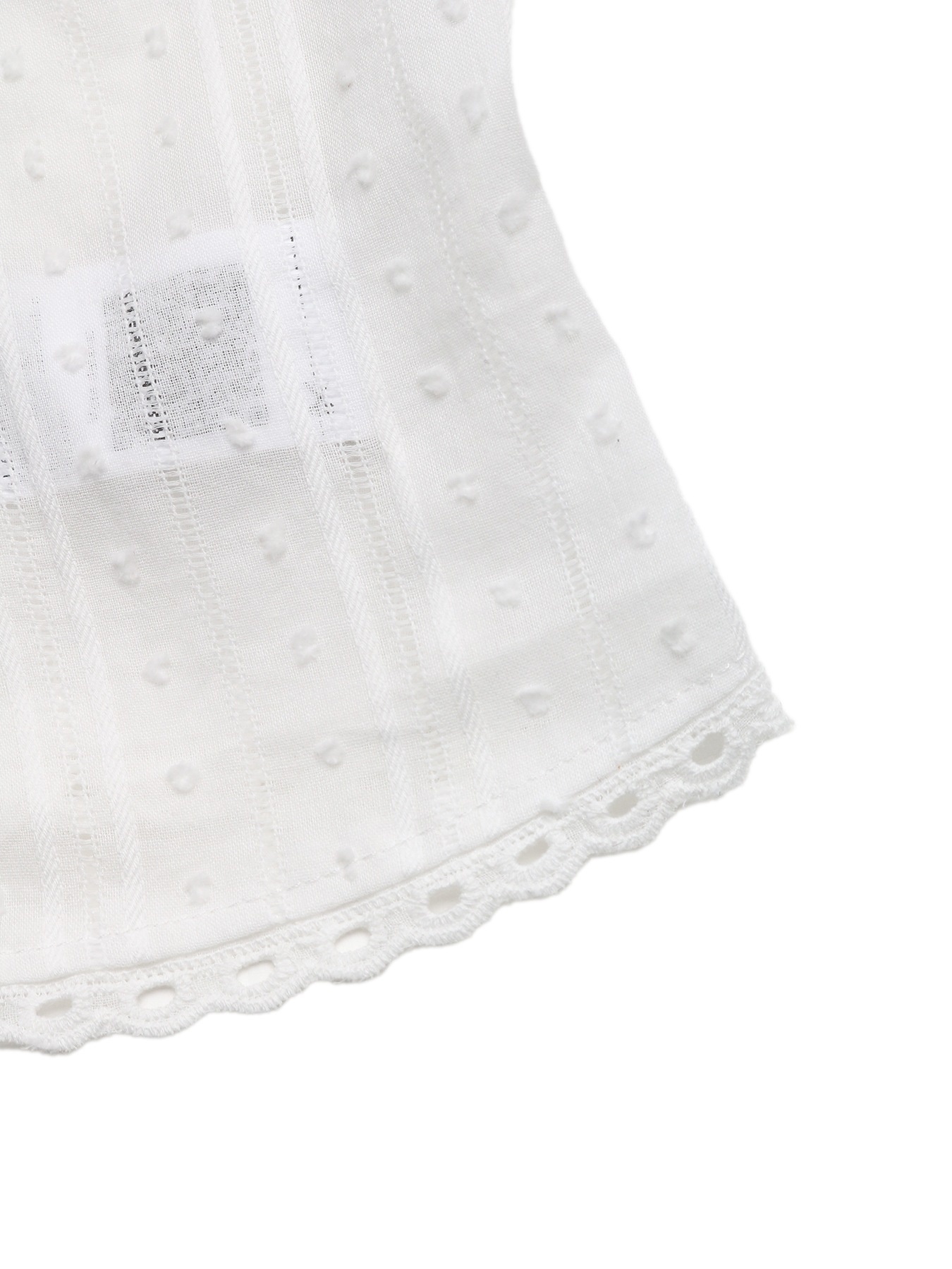 Top bianco senza maniche con scollo a V e allacciatura sul davanti, con bordo in pizzo.