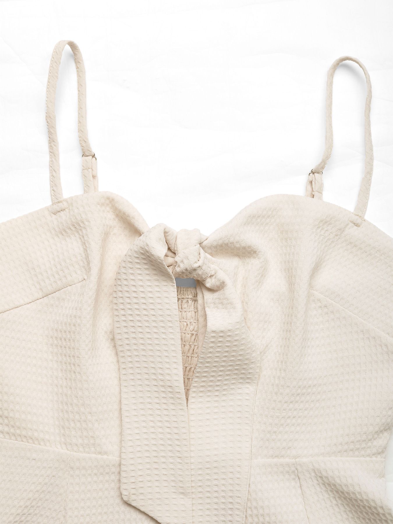 Mono corto texturizado para mujer con lazo frontal y ribete de borlas.