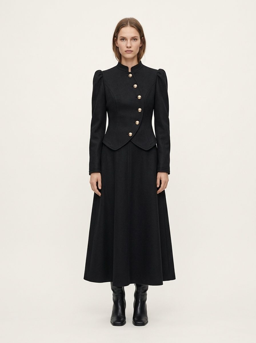 Completo da donna nero composto da giacca asimmetrica con bottoni e gonna lunga.