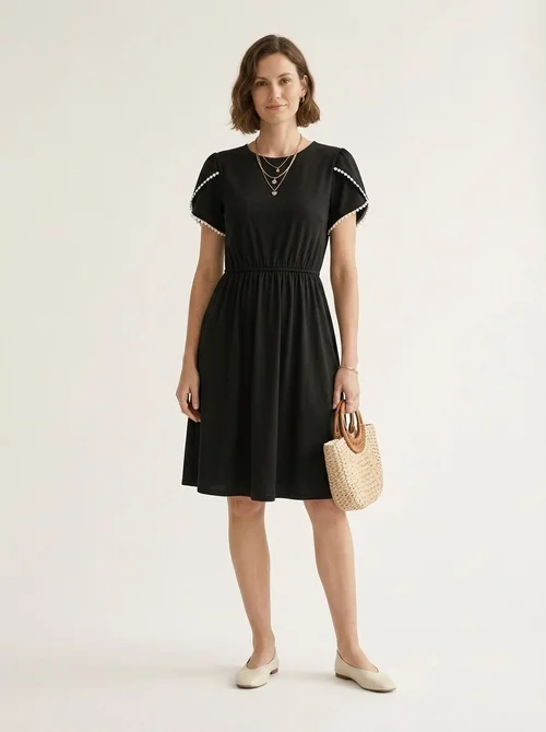 Elegante vestido negro de manga corta con bolsillos y ribete blanco.