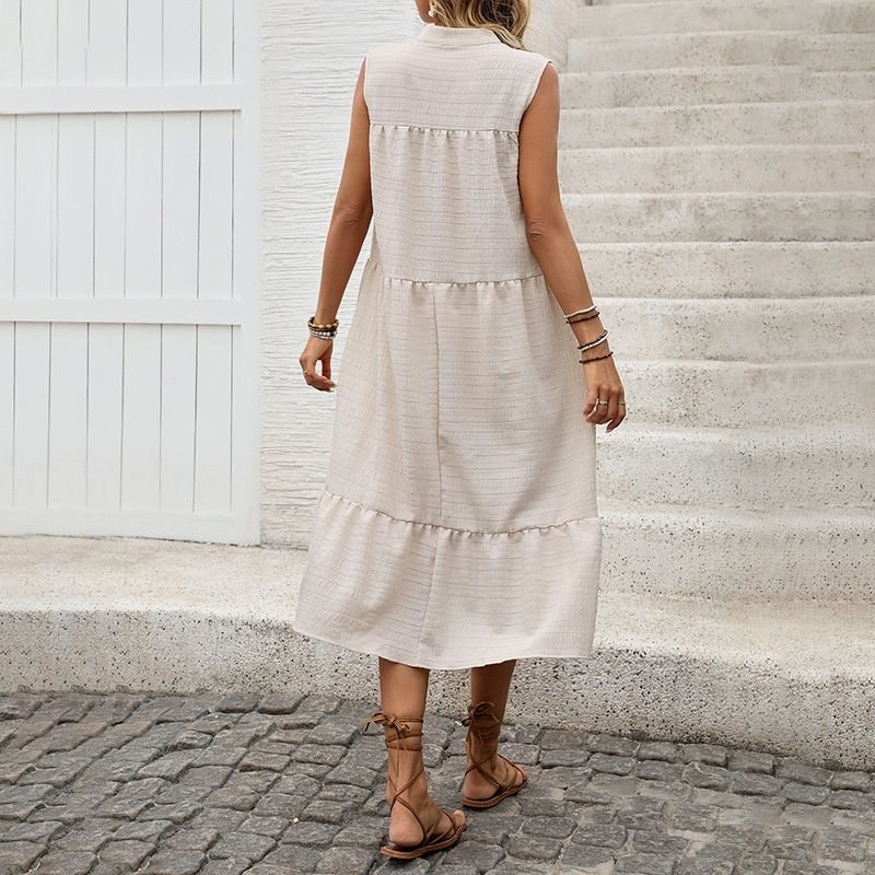 Vestido midi bohemio sin mangas con volantes y cuello con borlas.