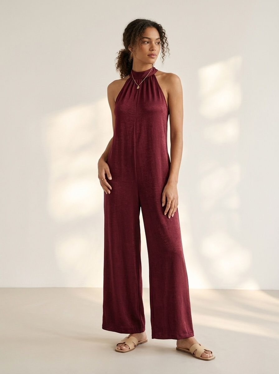 Elegante mono de pierna ancha con cuello halter y detalle de lazo en la espalda.