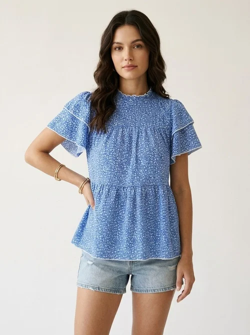 Blusa azul con volantes florales y mangas peplum.