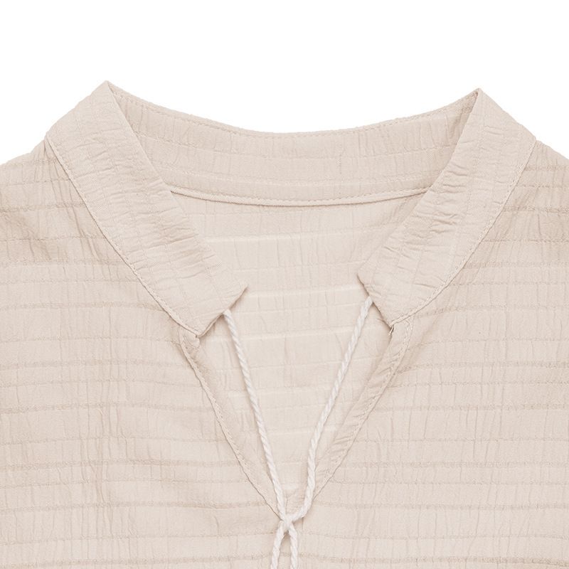 Vestido midi bohemio sin mangas con volantes y cuello con borlas.