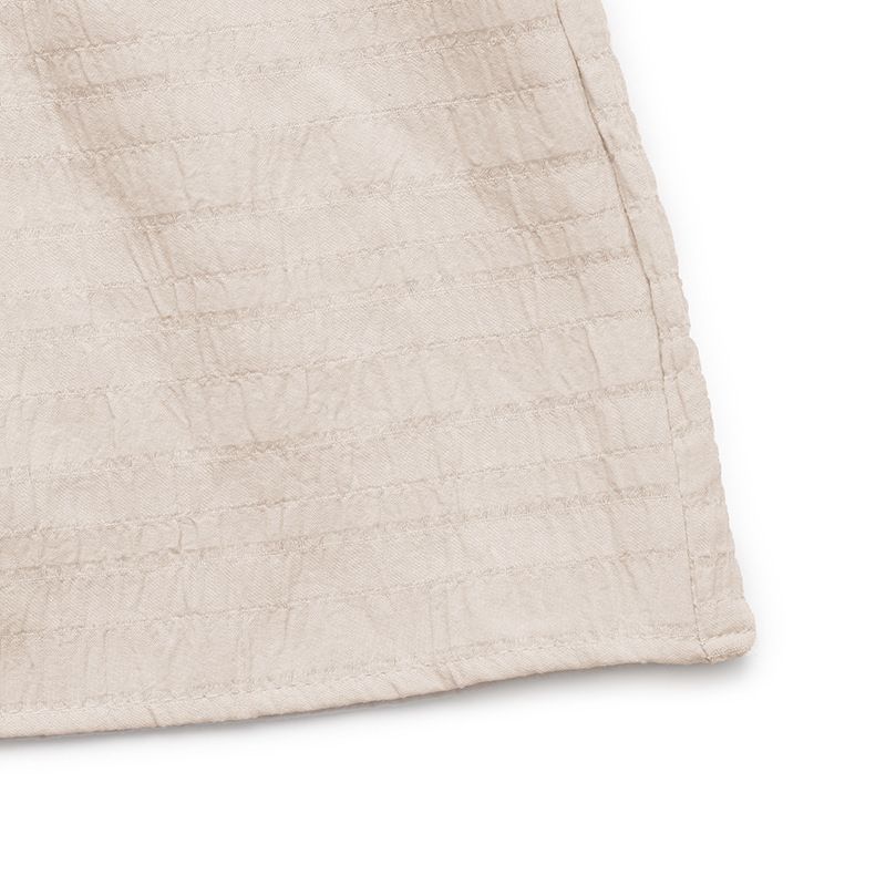 Vestido midi bohemio sin mangas con volantes y cuello con borlas.