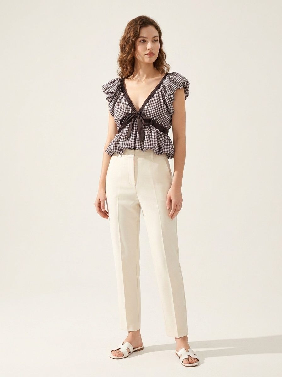 Elegante camicetta peplum a quadretti vichy con fiocco e maniche a sbuffo.