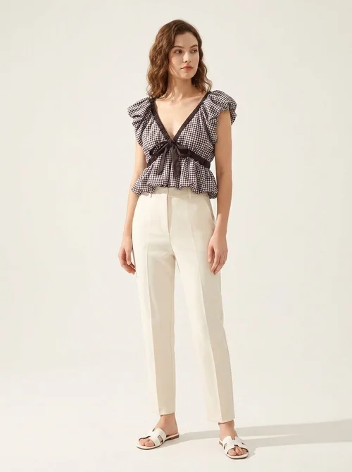 Elegante camicetta peplum a quadretti vichy con fiocco e maniche a sbuffo.