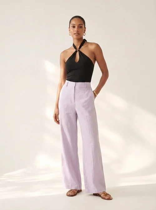 Elegante crop top nero con scollo all'americana e dettaglio ad anello dorato.
