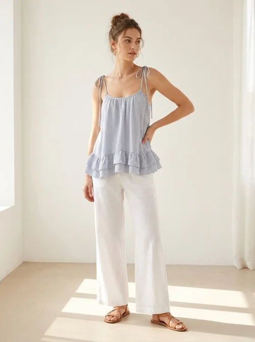 Elegante top a canotta con volant a righe blu e bianche e laccetti sulle spalle.