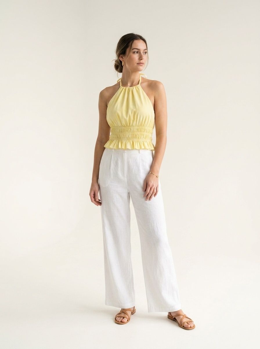 Elegante crop top giallo con scollo all'americana, orlo arricciato e volant.