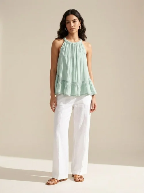 Elegante top all'americana in tessuto stropicciato con volant e finiture in pizzo.