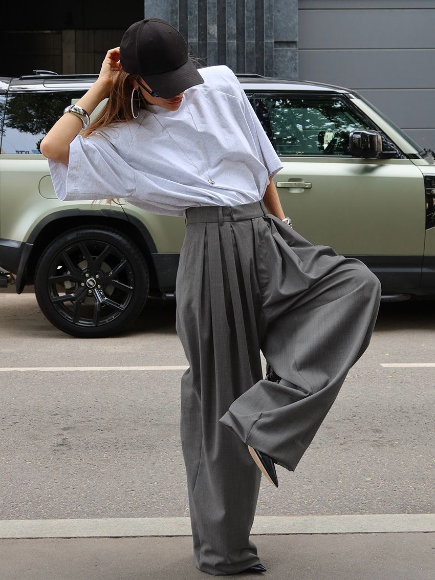 Pantalones grises de mujer de talle alto y pierna ancha con pliegues.