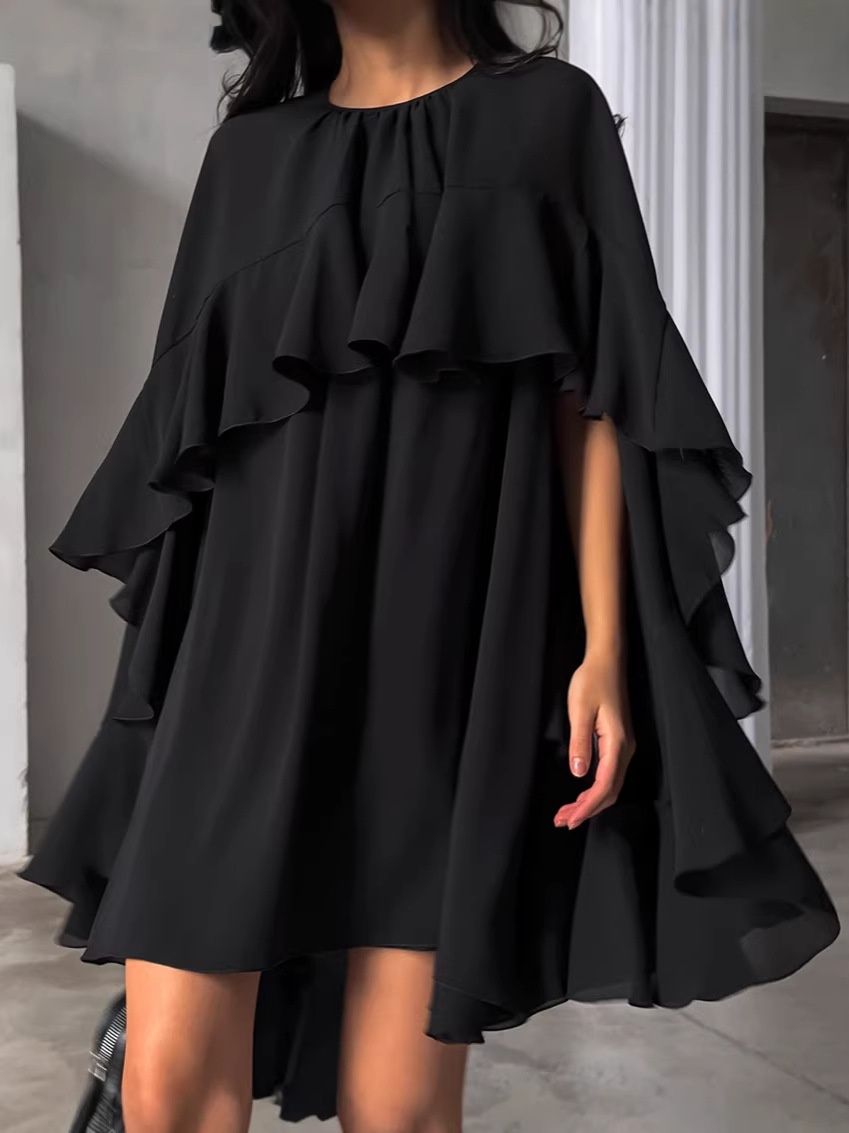 Elegante minivestido negro con volantes y falda fluida de varias capas.