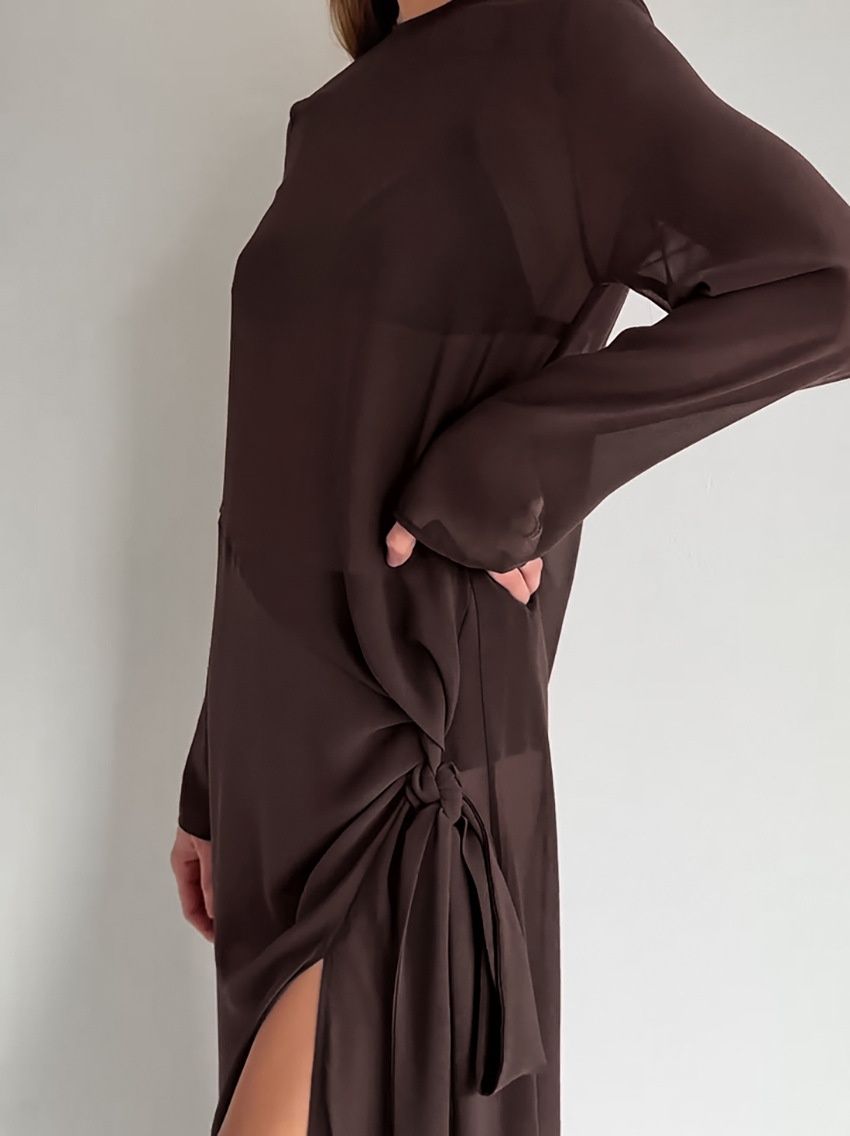 Vestido largo transparente con abertura lateral y detalle de nudo.