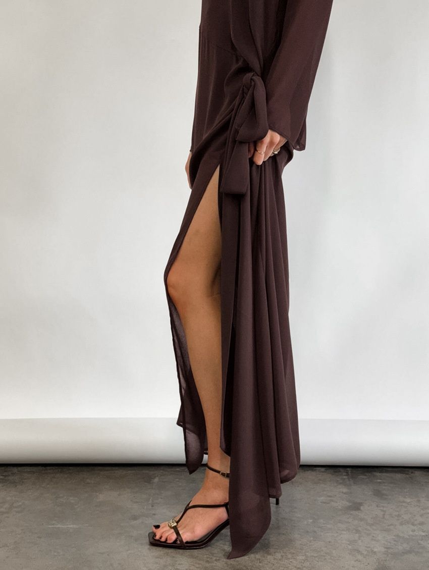 Vestido largo transparente con abertura lateral y detalle de nudo.