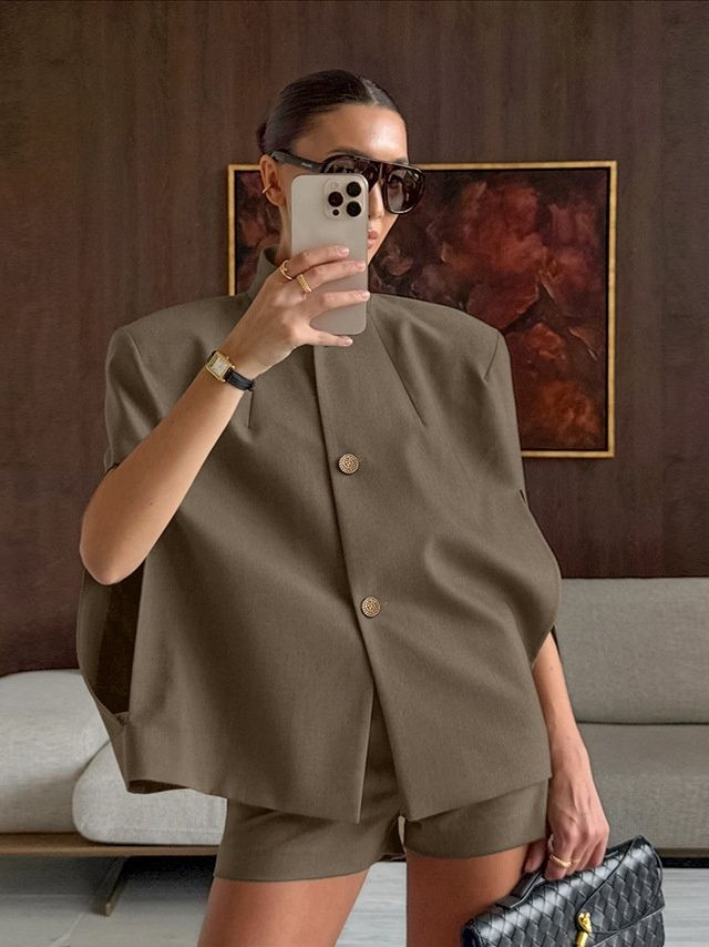 Elegante conjunto de chaqueta tipo capa y pantalones cortos en verde militar.