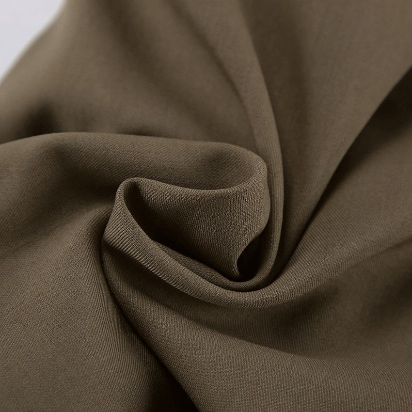 Elegante conjunto de chaqueta tipo capa y pantalones cortos en verde militar.