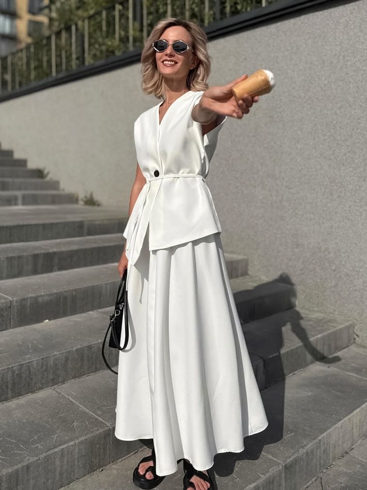 Elegante conjunto de top cruzado y falda larga blanca.
