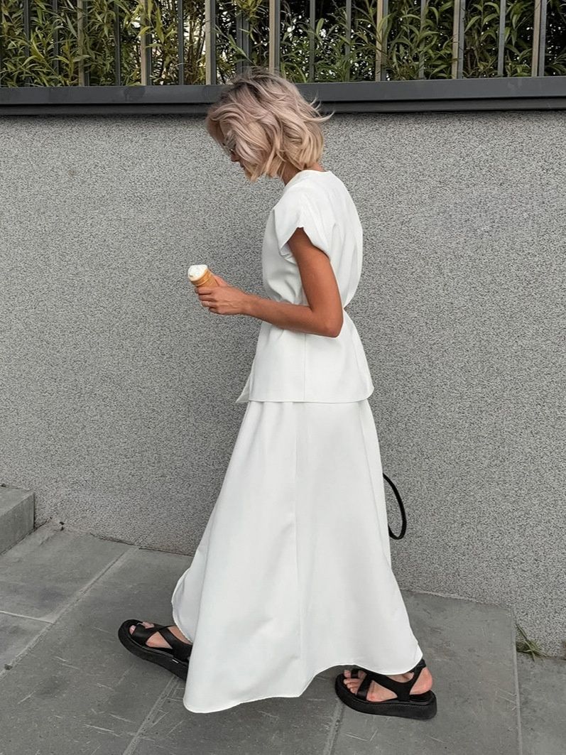 Elegante conjunto de top cruzado y falda larga blanca.