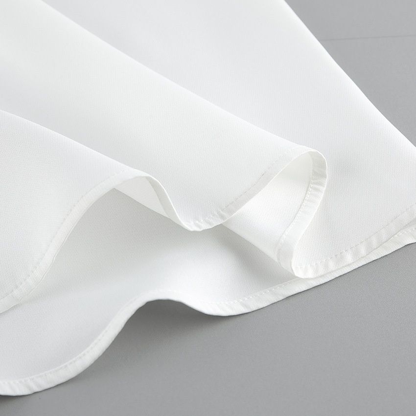 Elegante conjunto de top cruzado y falda larga blanca.