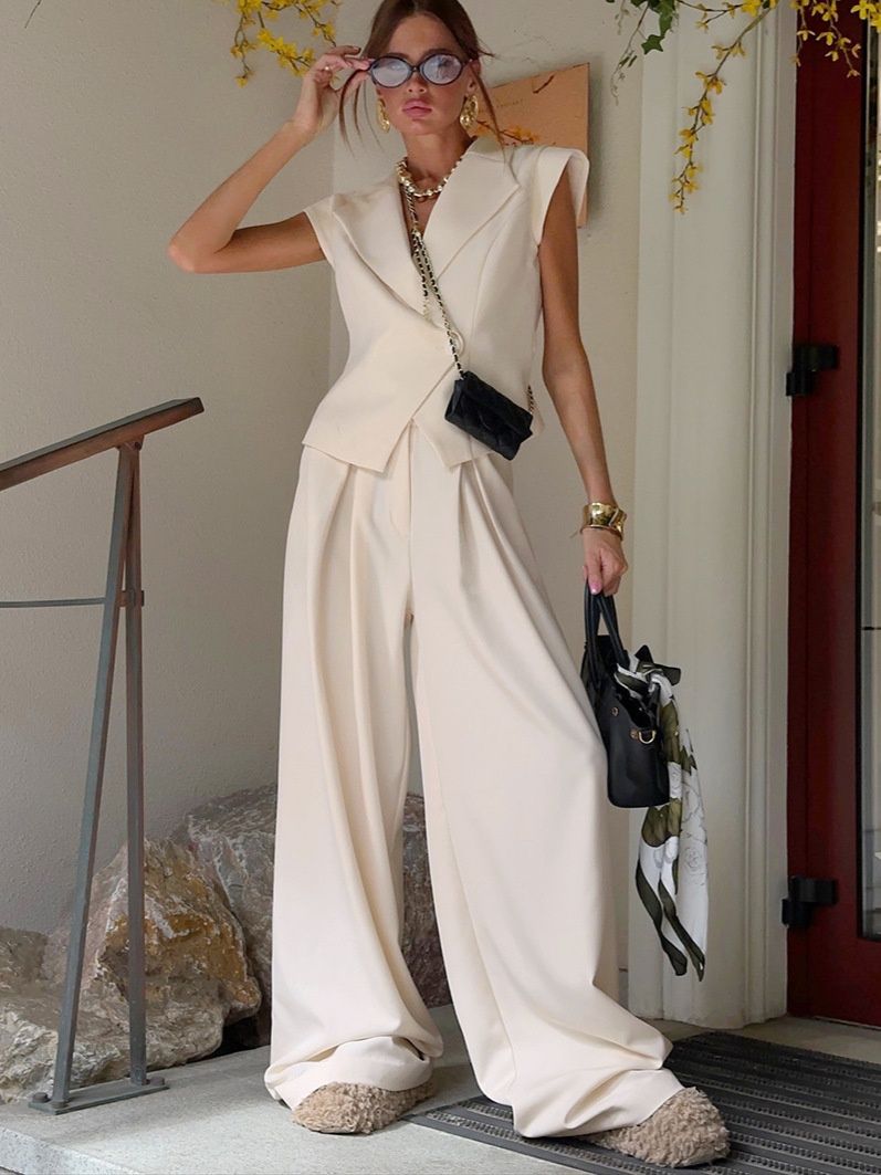 Conjunto de chaleco tipo blazer sin mangas y pantalones de pierna ancha en color blanco roto.