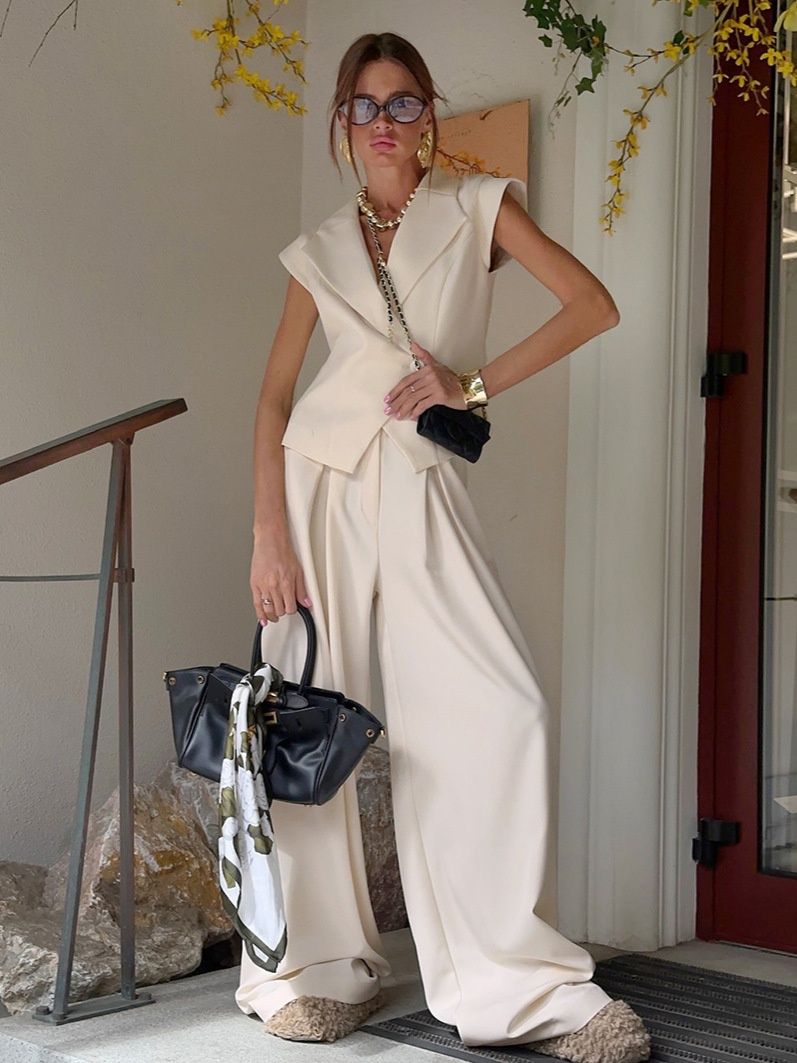 Conjunto de chaleco tipo blazer sin mangas y pantalones de pierna ancha en color blanco roto.