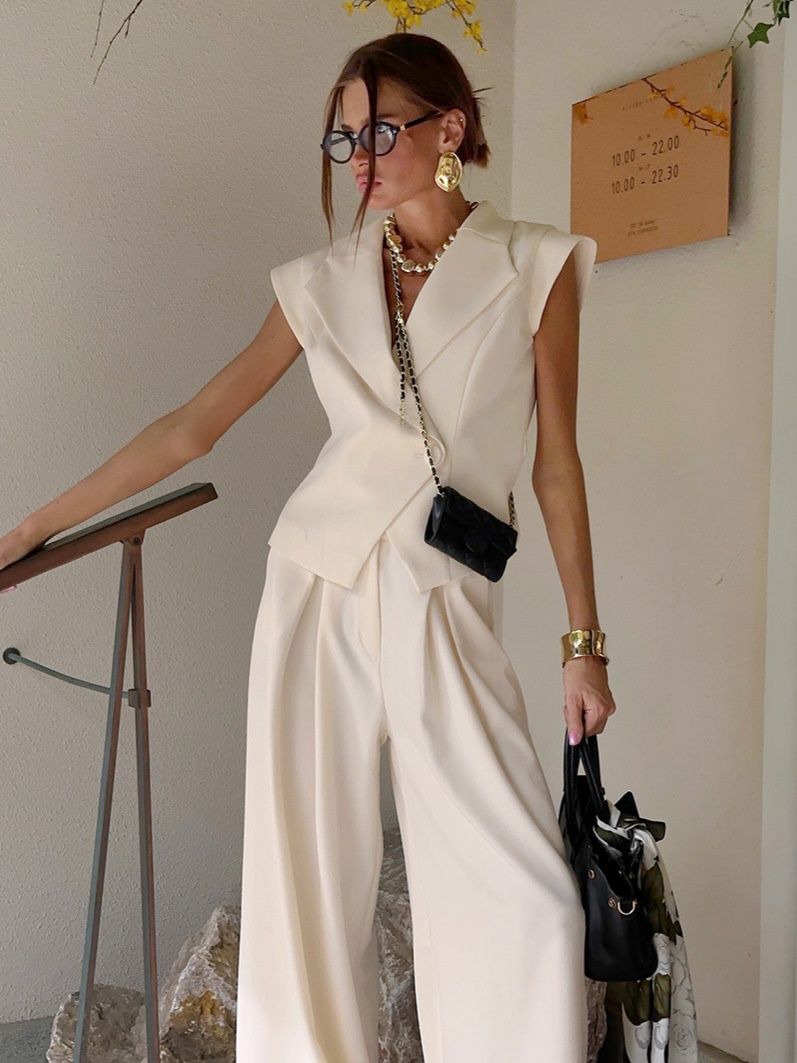 Conjunto de chaleco tipo blazer sin mangas y pantalones de pierna ancha en color blanco roto.
