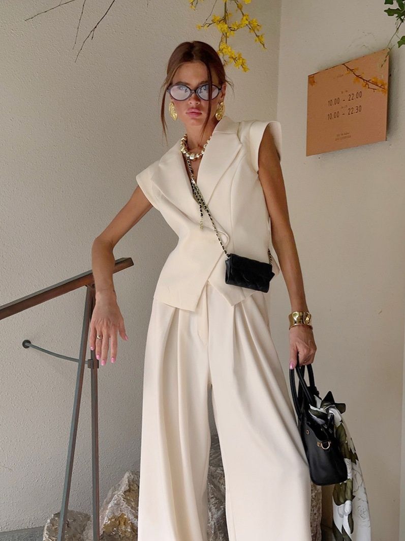 Conjunto de chaleco tipo blazer sin mangas y pantalones de pierna ancha en color blanco roto.