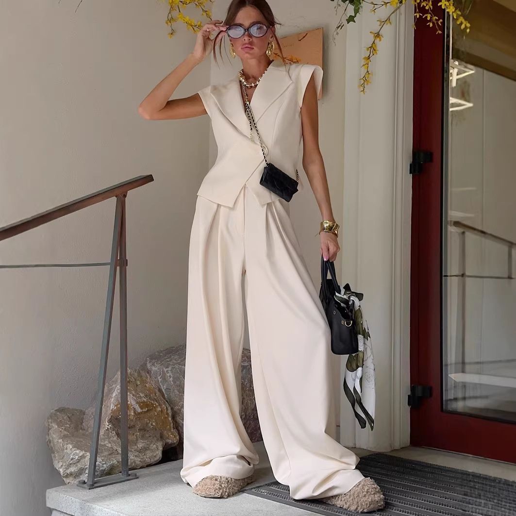 Conjunto de chaleco tipo blazer sin mangas y pantalones de pierna ancha en color blanco roto.