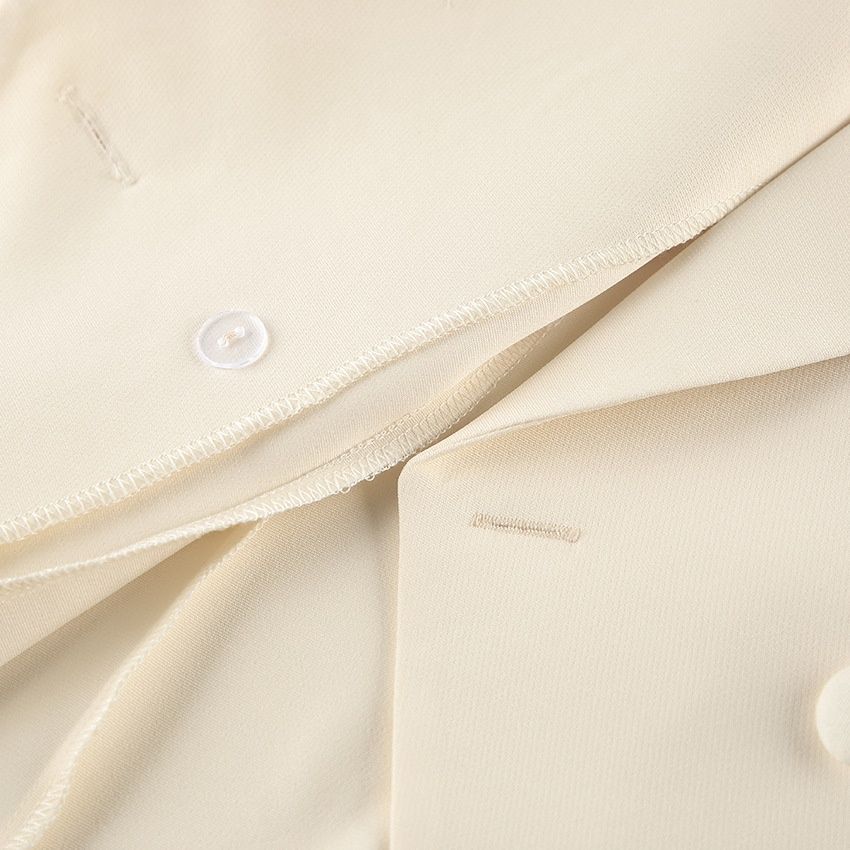 Conjunto de chaleco tipo blazer sin mangas y pantalones de pierna ancha en color blanco roto.