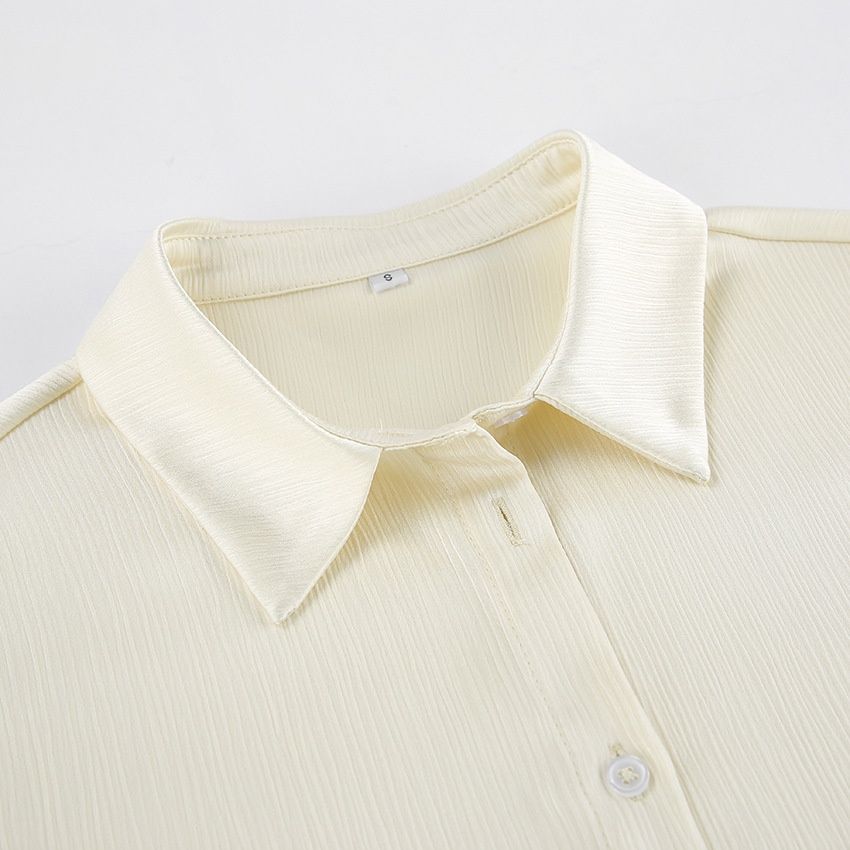 Conjunto de camisa acanalada color blanco roto y pantalón de pierna ancha.