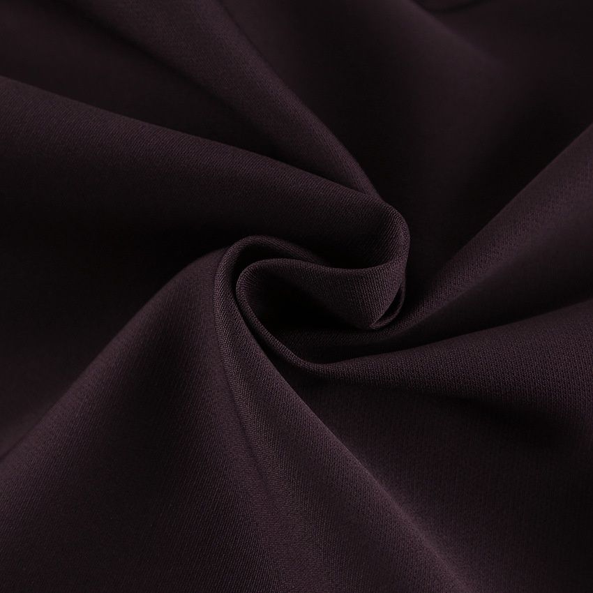 Traje de mujer color marrón chocolate con chaqueta peplum y pantalón de pierna ancha.