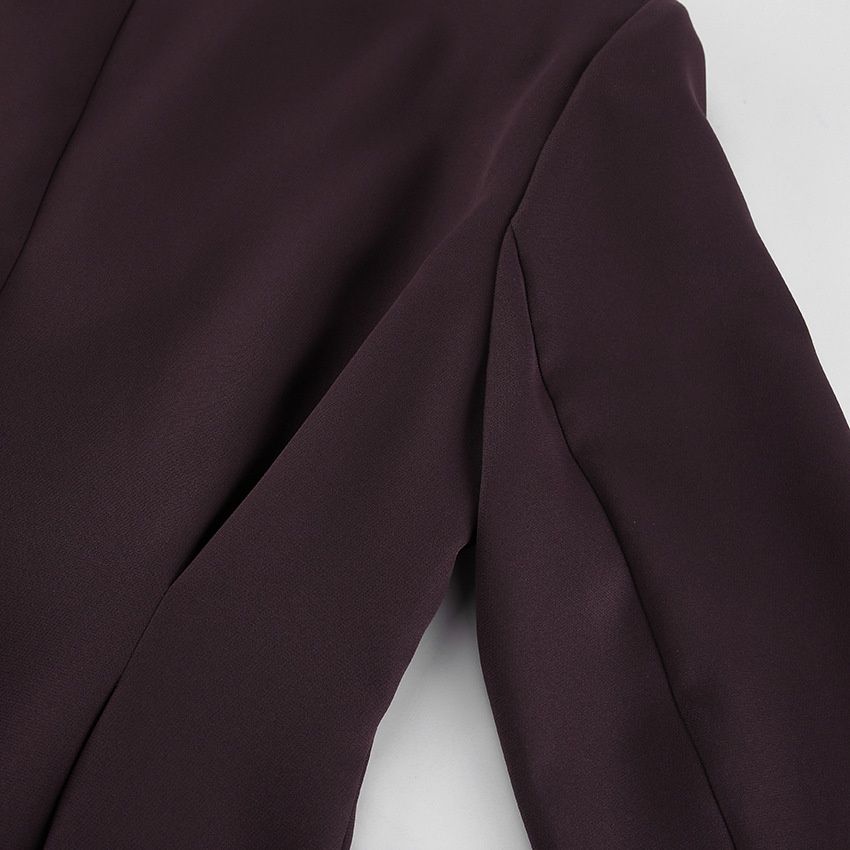 Traje de mujer color marrón chocolate con chaqueta peplum y pantalón de pierna ancha.