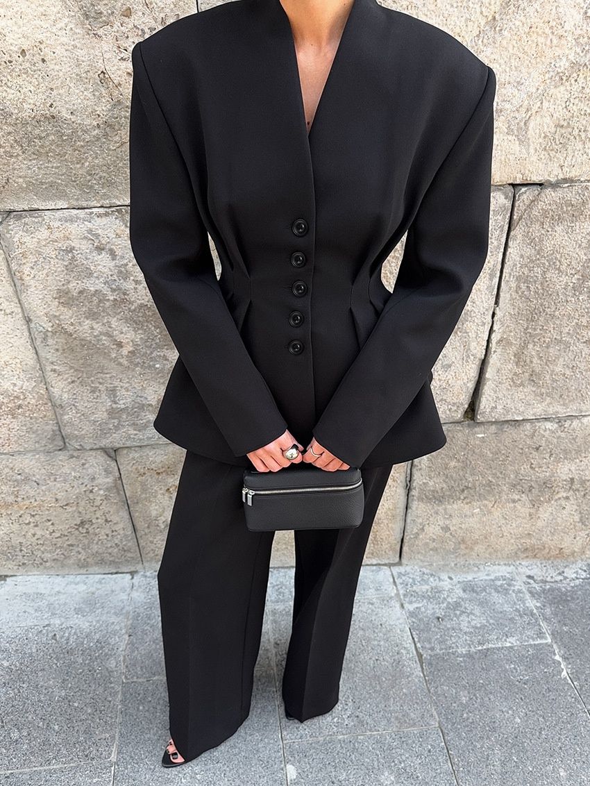 Elegante conjunto de chaqueta peplum negra y pantalón de pierna ancha.