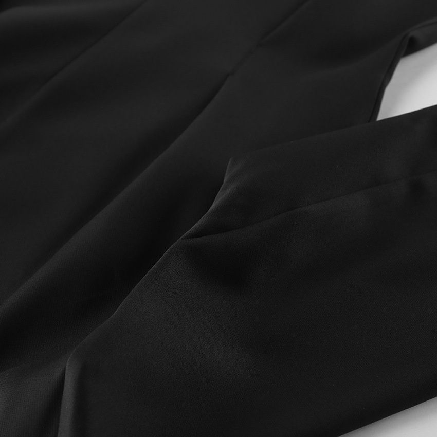 Elegante conjunto de chaqueta peplum negra y pantalón de pierna ancha.