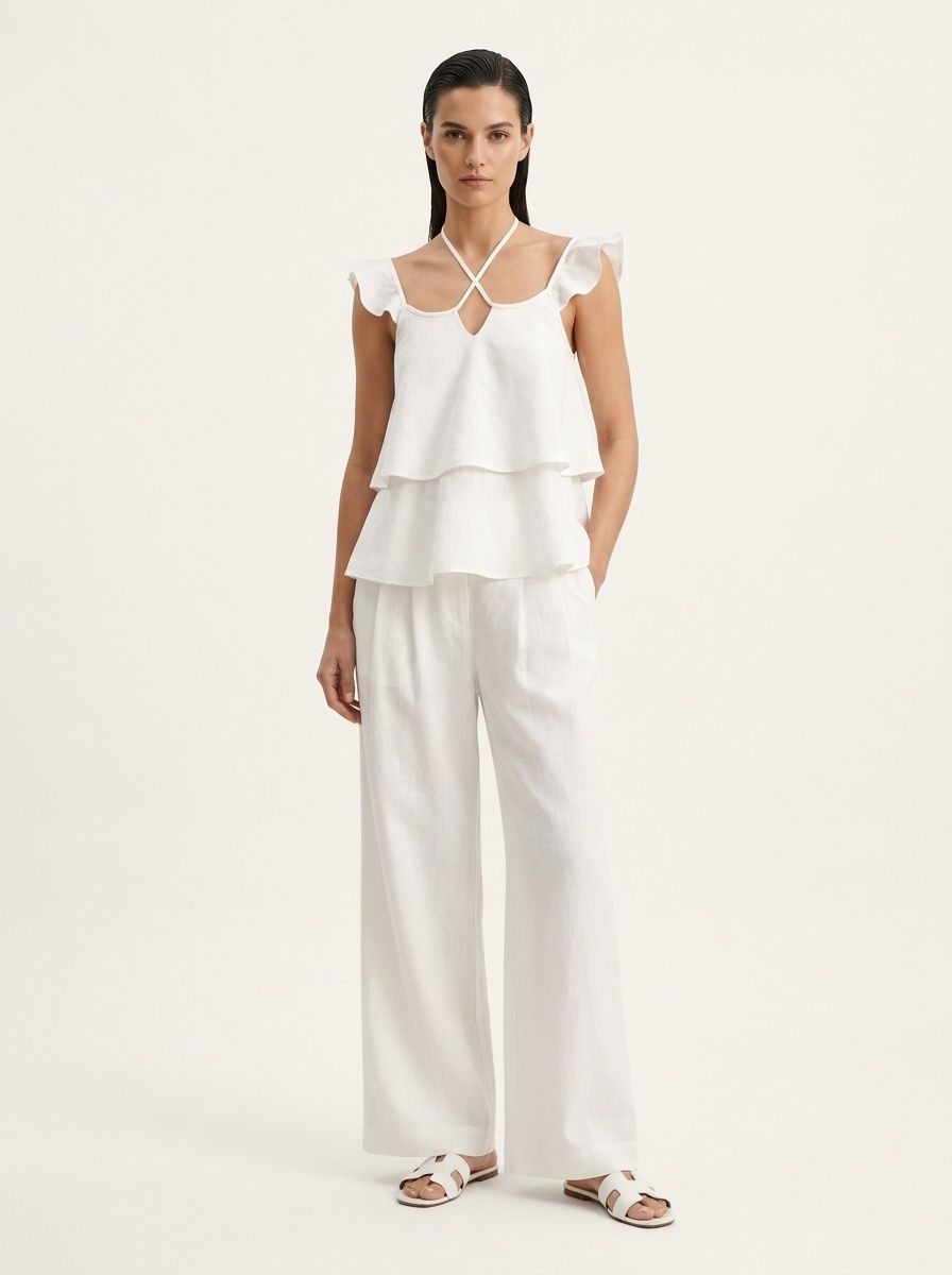 Completo da donna composto da top a canotta bianco con volant e pantaloni a gamba larga.