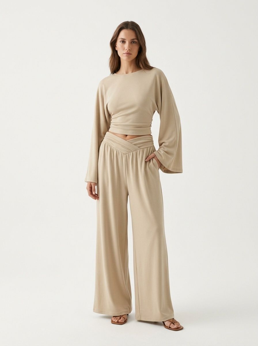 Completo composto da pantaloni a gamba larga e top corto a maniche lunghe.