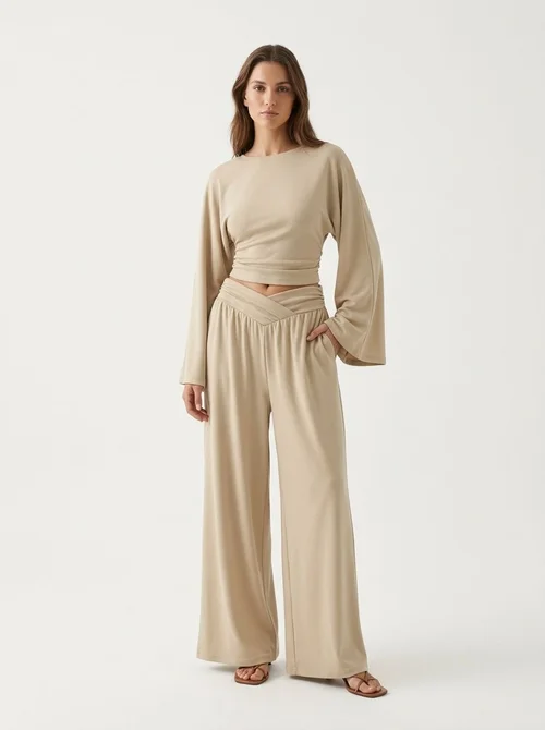 Completo composto da pantaloni a gamba larga e top corto a maniche lunghe.