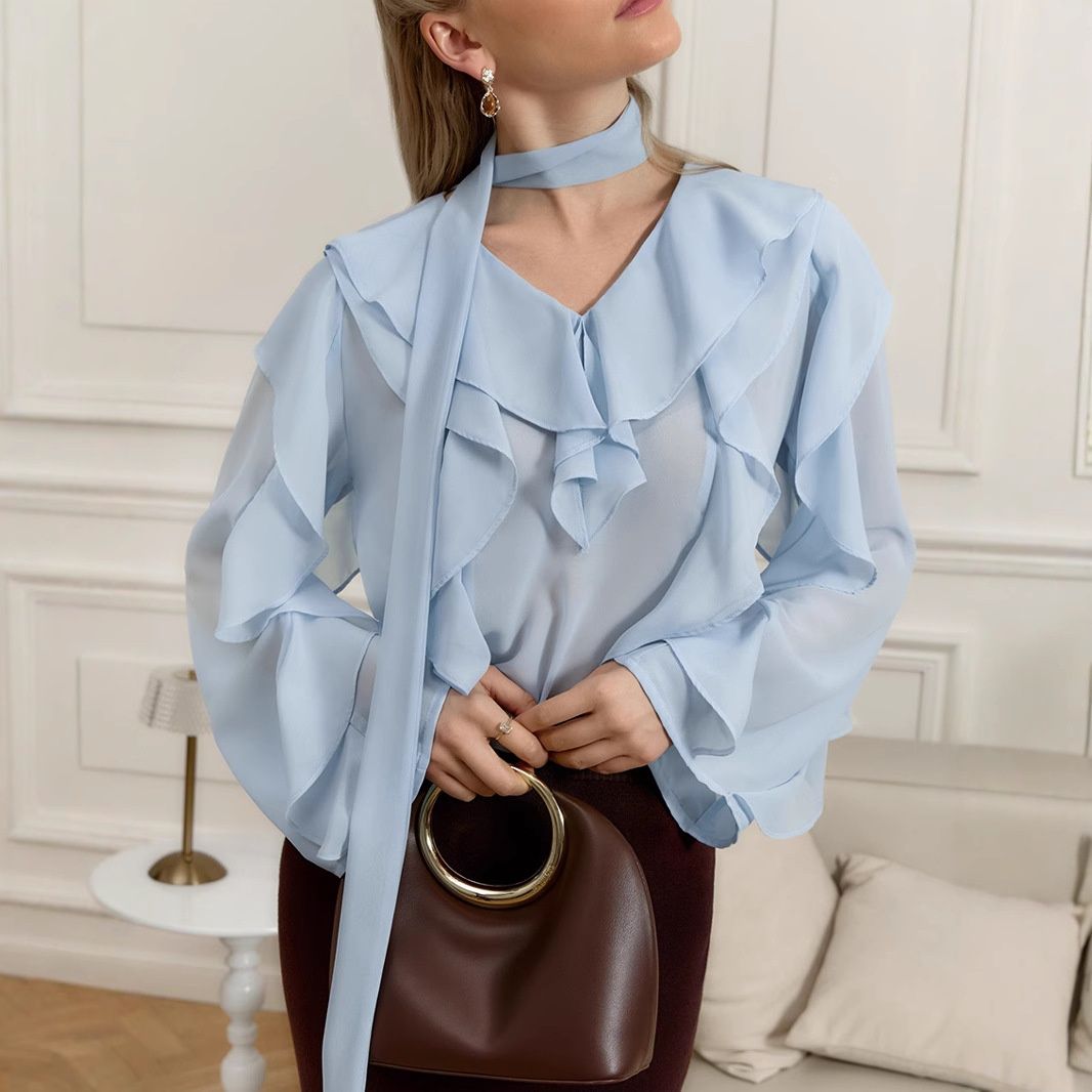 Blusa de gasa con volantes y lazo en el cuello.